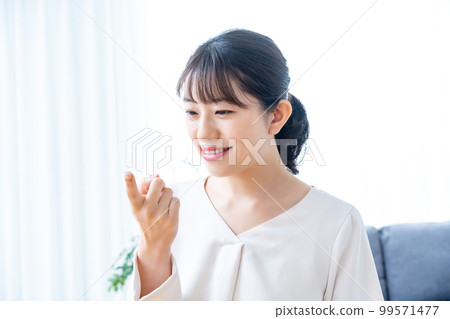 Women trying to wear contact lenses 99571477