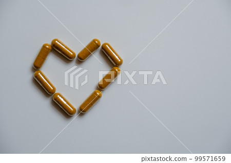 Several brown capsules, arranged in a heart shape Several brown capsules, arranged in a heart shape 99571659