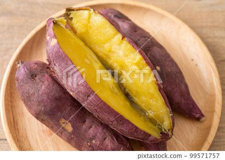 Grilled or baked Japanese sweet potatoes on wood plate 99571757