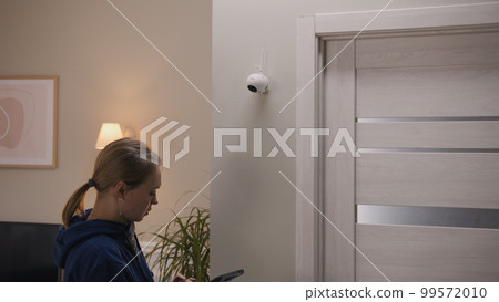 Woman sets up CCTV camera using tablet Woman sets up CCTV camera using tablet 99572010