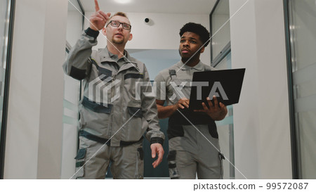Men install CCTV cameras in office hallway Men install CCTV cameras in office hallway 99572087