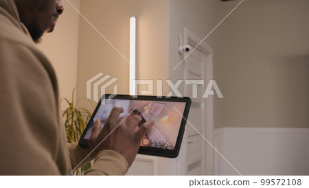 African American man checks security camera 99572108