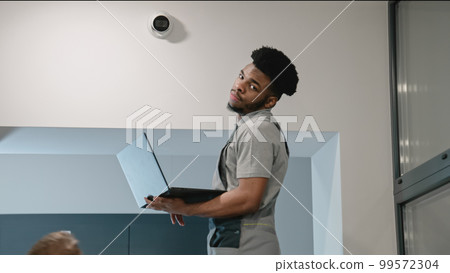 Upset African American worker looks at camera Upset African American worker looks at camera 99572304