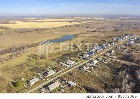 Aerial view of a village in Siberia, expanses of fields and birch groves in autumn Aerial view of a village in Siberia, expanses of fields and birch groves in autumn 99572369