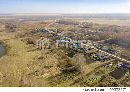 Aerial view of a village in Siberia, expanses of fields and birch groves in autumn Aerial view of a village in Siberia, expanses of fields and birch groves in autumn 99572371