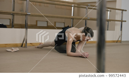 Female ballet dancer in training suit makes lunges 99572443