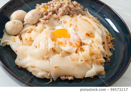 dried spicy noodles with minced pork, meatballs and egg 99573217