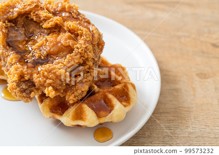 fried chicken waffle with honey or maple syrup fried chicken waffle with honey or maple syrup 99573232