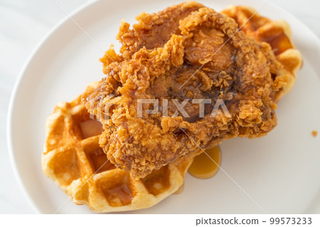 fried chicken waffle with honey or maple syrup fried chicken waffle with honey or maple syrup 99573233