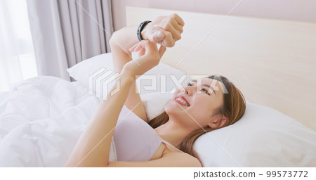 Woman wake up with smartwatch 99573772