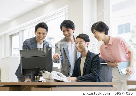 Four office workers looking at a desktop computer display Four office workers looking at a desktop computer display 99574039