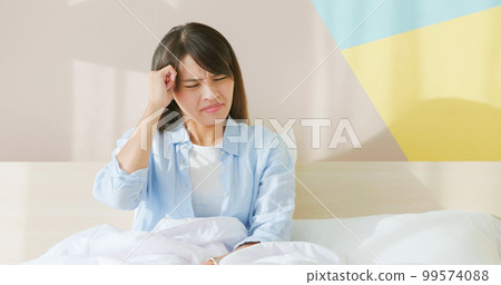 woman has headache on bed 99574088