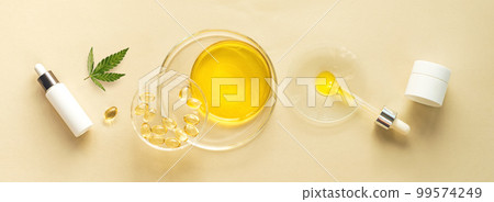 Cannabis, capsules, CBD oil in pipette in glass labware and cosmetics packaging 99574249