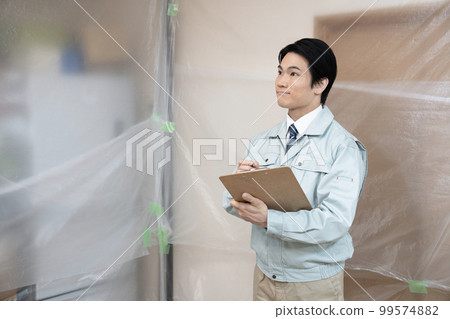 Site supervisor with drawings at the renovation site Site supervisor with drawings at the renovation site 99574882