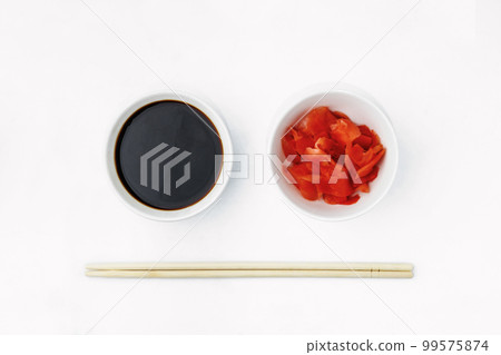 Funny face image of emoticon from soy sauce, pickled ginger and chopsticks, isolated on a white background. Creative oriental cuisine, restaurant concept. Copy space Funny face image of emoticon from soy sauce, pickled ginger and chopsticks, isolated on a white background. Creative oriental cuisine, restaurant concept. Copy space 99575874