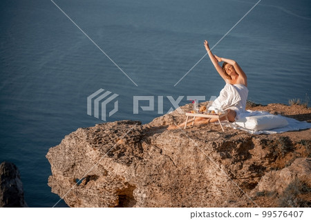Woman wake up in bed wuth duvet and pillow over nature sea background outdoors. Back view. Good morning. Freedom concept. 99576407