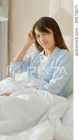 woman has headache on bed 99578675