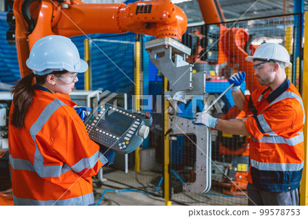 engineer team worker service  robot arm assembly machine in modern metal industry factory 99578753