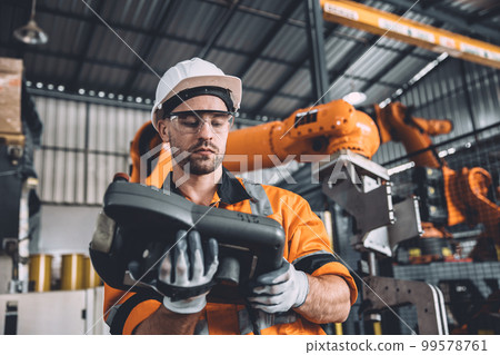 Engineer team service robot welding working in automation factory. Male worker operate robotic arm software hand controller in automated manufacturing industry technology. Engineer team service robot welding working in automation factory. Male worker operate robotic arm software hand controller in automated manufacturing industry technology. 99578761