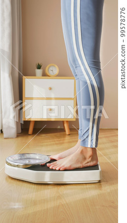 woman measure weight on scale woman measure weight on scale 99578776