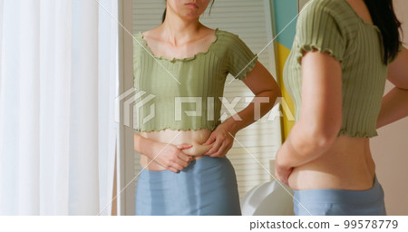 woman pinch excessive fat belly woman pinch excessive fat belly 99578779