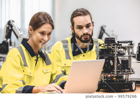 Electronics Engineer Team Works with IOT Robot Checking Source Code and Program AI System. Automation Computer Science Research Laboratory with Specialists Working. 99579266