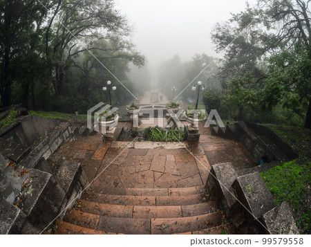 Soft focus. Beautiful old stone staircase in the misty park of Zheleznovodsk. Old stone staircase in the autumn misty park. Stairs down. Soft focus. Beautiful old stone staircase in the misty park of Zheleznovodsk. Old stone staircase in the autumn misty park. Stairs down. 99579558