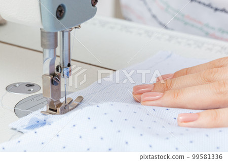 Female hands of a master tailor at work, a sewing machine needle Female hands of a master tailor at work, a sewing machine needle 99581336