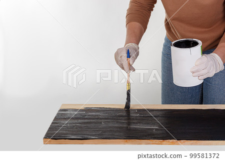 painting wooden background, hand with brush and can of paint painting wooden background, hand with brush and can of paint 99581372