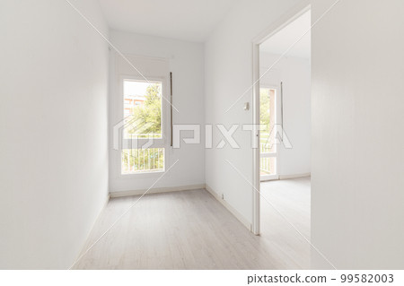 View of an empty white bright room with window without furniture after painting and renovation with wooden floor and baseboards. Concept of beautiful laconic interior for various inspiring ideas View of an empty white bright room with window without furniture after painting and renovation with wooden floor and baseboards. Concept of beautiful laconic interior for various inspiring ideas 99582003