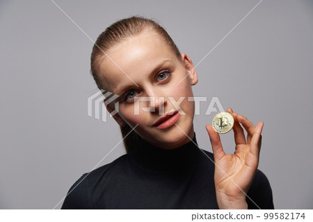 Closeup of young female holding Crypto coin symbol in hand. Closeup of young female holding Crypto coin symbol in hand. 99582174