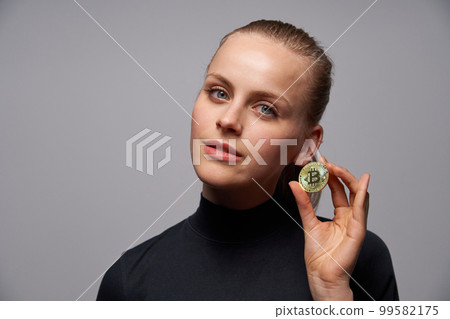 Closeup of young female holding Crypto coin symbol in hand. Closeup of young female holding Crypto coin symbol in hand. 99582175