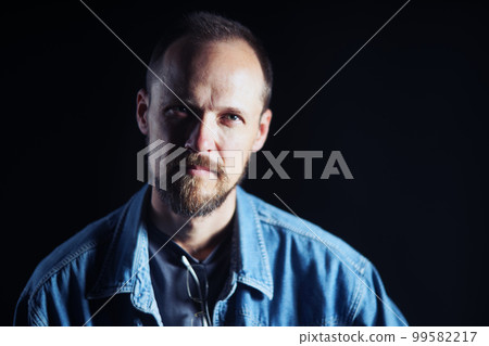 Concentraited middle age man in denim shirt looking squinting at camera 99582217