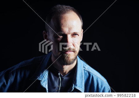 Concentraited middle age man in denim shirt looking squinting to the side 99582218