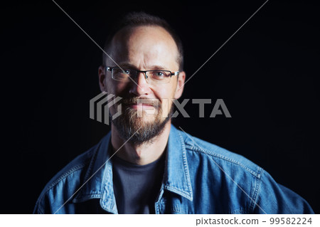 Authentic smiling middle age man in denim shirt and eyeglasses looking at camera Authentic smiling middle age man in denim shirt and eyeglasses looking at camera 99582224