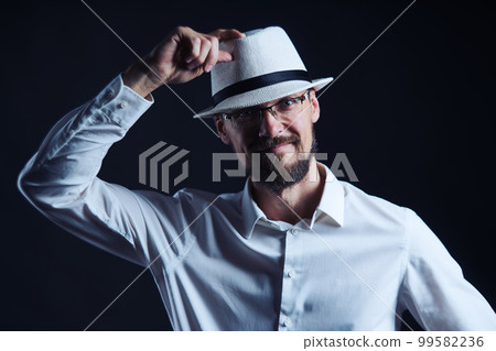 Smiling middle age man in hat lifting his hat 99582236