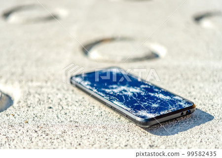 A smartphone with a broken screen when dropped A smartphone with a broken screen when dropped 99582435