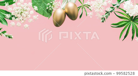 Golden Easter eggs in assorted floral and jungle tree green leaves and white flowers corner border on peach pink. Natural sustainable environment friendly cosmetics mockup flat lay banner 99582528