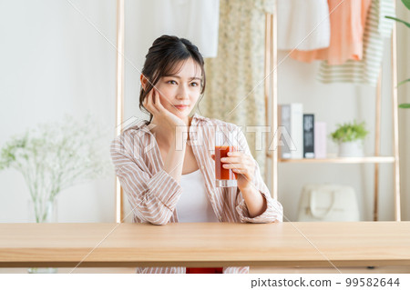 A young woman drinking vegetable juice A young woman drinking vegetable juice 99582644