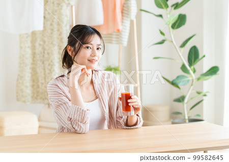 A young woman drinking vegetable juice A young woman drinking vegetable juice 99582645