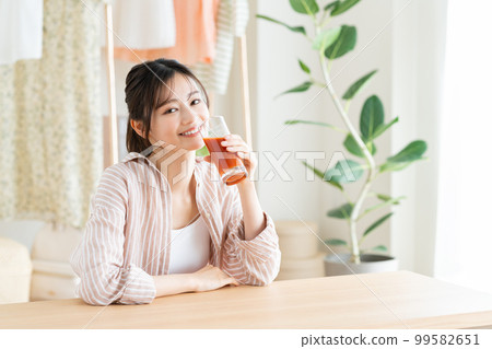 A young woman drinking vegetable juice A young woman drinking vegetable juice 99582651