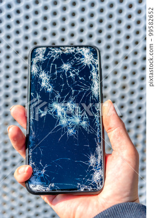 Smartphone fence background with broken screen after dropping Smartphone fence background with broken screen after dropping 99582652