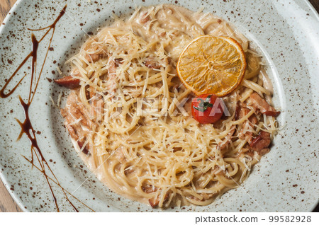 Italian pasta sprinkled with cheese in a plate with streaks of sauce 99582928