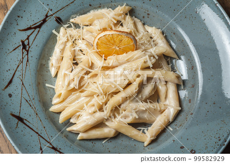 Italian pasta sprinkled with cheese in a plate with streaks of sauce 99582929