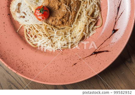 Italian pasta sprinkled with cheese in a plate with streaks of sauce Italian pasta sprinkled with cheese in a plate with streaks of sauce 99582932