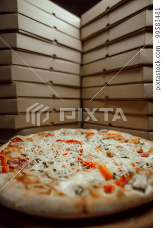 The boxes are on top of each other with one pizza between them The boxes are on top of each other with one pizza between them 99583481