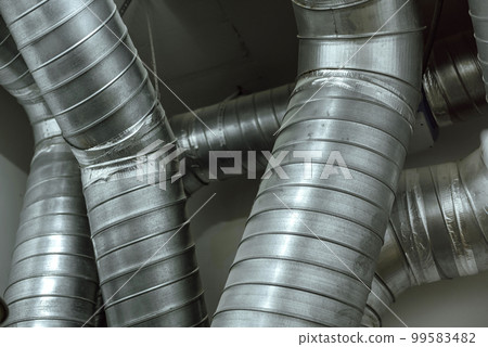 Ventilation pipes are intertwined under the ceiling 99583482
