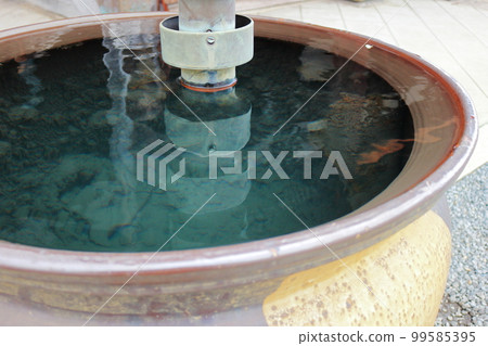 Rainwater accumulated in a large bottle reflected on the swaying surface of the water 99585395