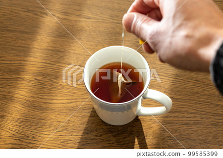 A tea bag soaked in a cup of hot water 99585399