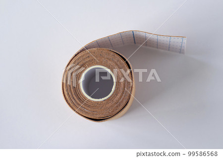 Roll of beige kinesio tapes on a white background 99586568